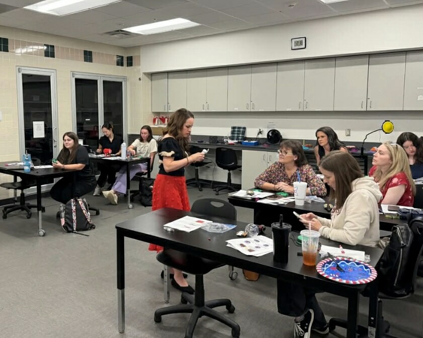 Teacher checks on Occupational Therapy students in a lab