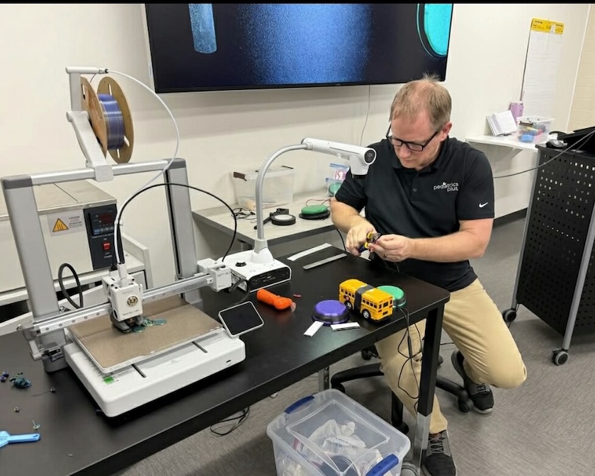 Man working with a 3-D printer.
